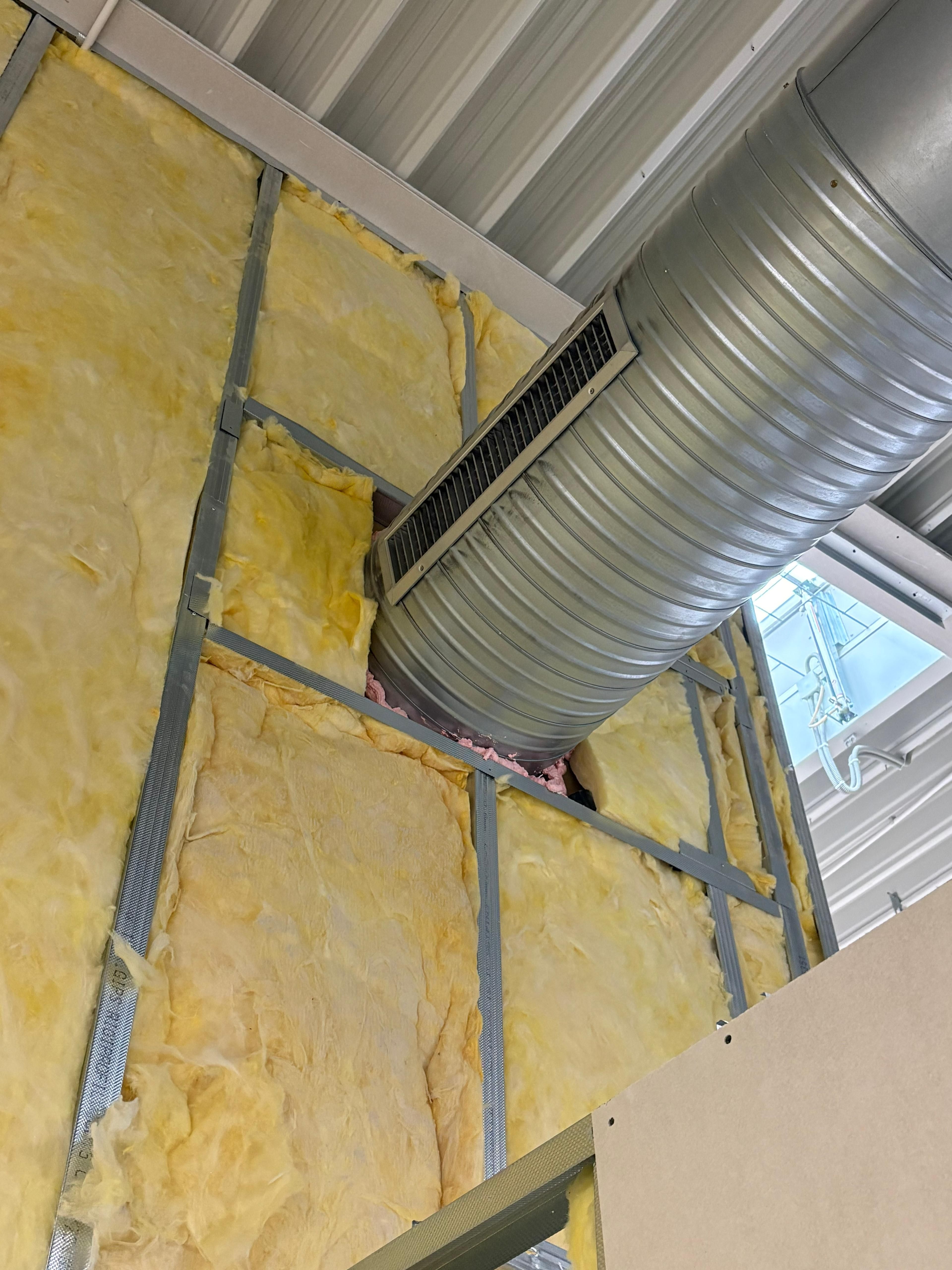 Izolație din vată minerală montată între profile metalice, în jurul tubulaturii de ventilație
